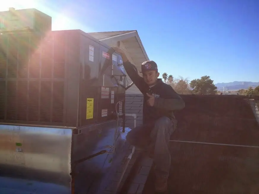 HVAC technician performing AC Tune-Up on a rooftop unit in Bridgewater Town